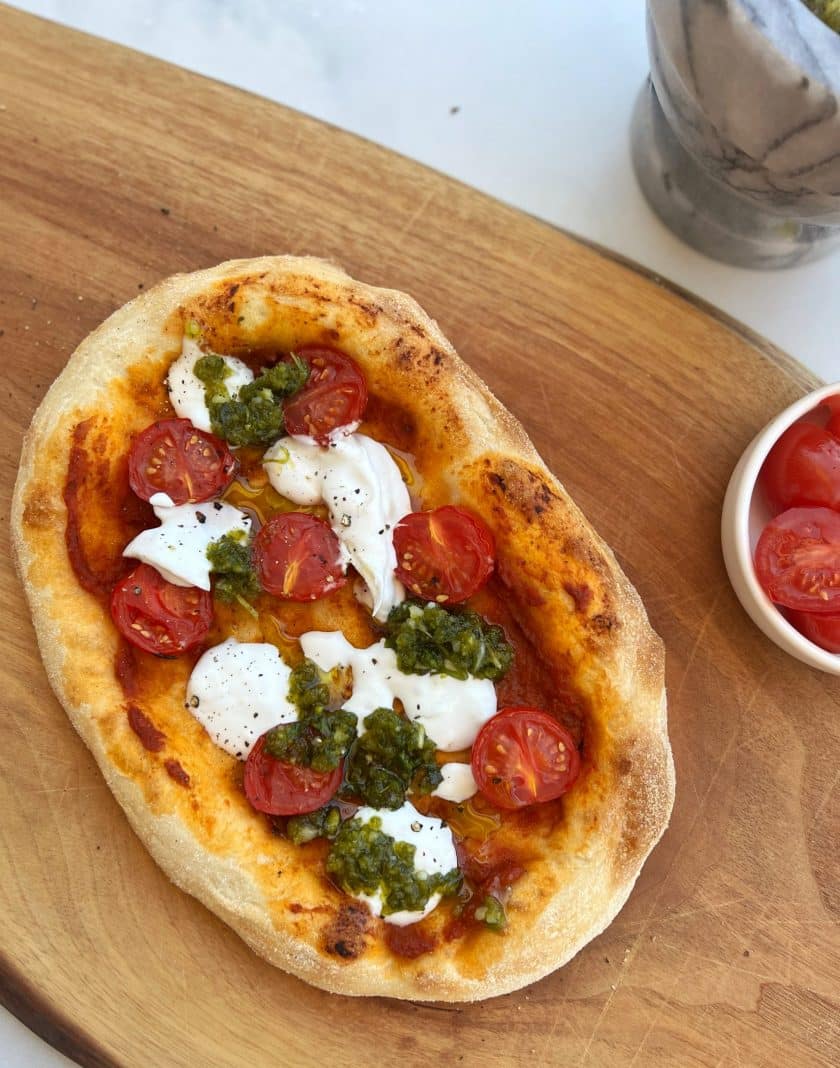 Pinsa mit Pesto auf einem Holzbrett