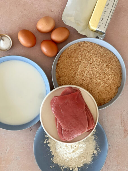 Zutaten: Eier Milch Mehl Semmelbrösel (Paniermehl) Kalbfleisch (z.B. Keule) Butter Zitronenspalten Preiselbeermarmelade