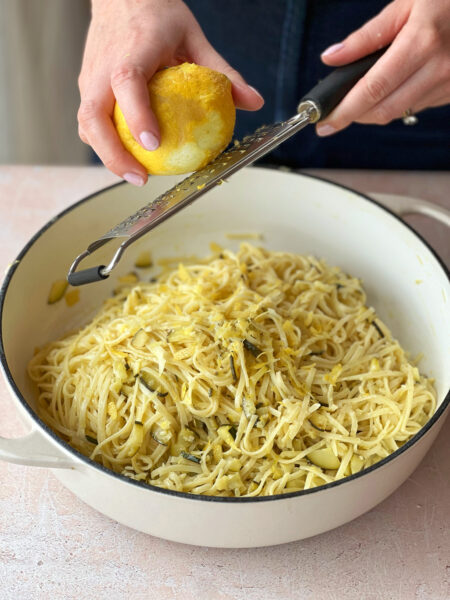 Die Pfanne vom Herd nehmen, die Hälfte des Parmesans zugeben und weiter kräftig durchschwenken. Den Vorgang mit dem restlichen Parmesan wiederholen, bis die Sauce richtig cremig ist.