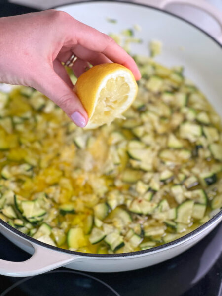 Kurz bevor die Nudeln fertig sind, den Grossteil des Zitronensaft und -abriebs in die Pfanne geben und mit Salz und Pfeffer würzen. Nudelwasser abschöpfen, in die Pfanne geben und die Hitze erhöhen, damit es sprudelnd einkocht. Die Nudeln mit einer Zange direkt aus dem Wasser in die Pfanne geben und etwa 2 Minuten mit der Zange in der Sauce schwenken, bis sie eindickt und glänzt. Bei Bedarf noch etwas mehr Nudelwasser zufügen, um die gewünschte Konsistenz zu erreichen.
