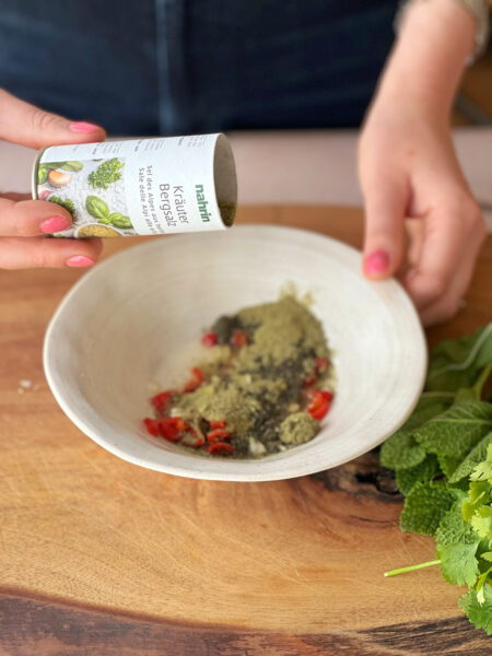 Für die Sauce, Knoblauchzehe zerdrücken, Chilischote aufschneiden, Kerne rausholen (die Kerne machen die Chili scharf. Falls du es scharf magst, die Kerne nicht entfernen) und in feine Ringe schneiden. Mit Sesamöl, Kräuter Bergsalz, Balsamico Bianco mischen und unter den Salat mischen.