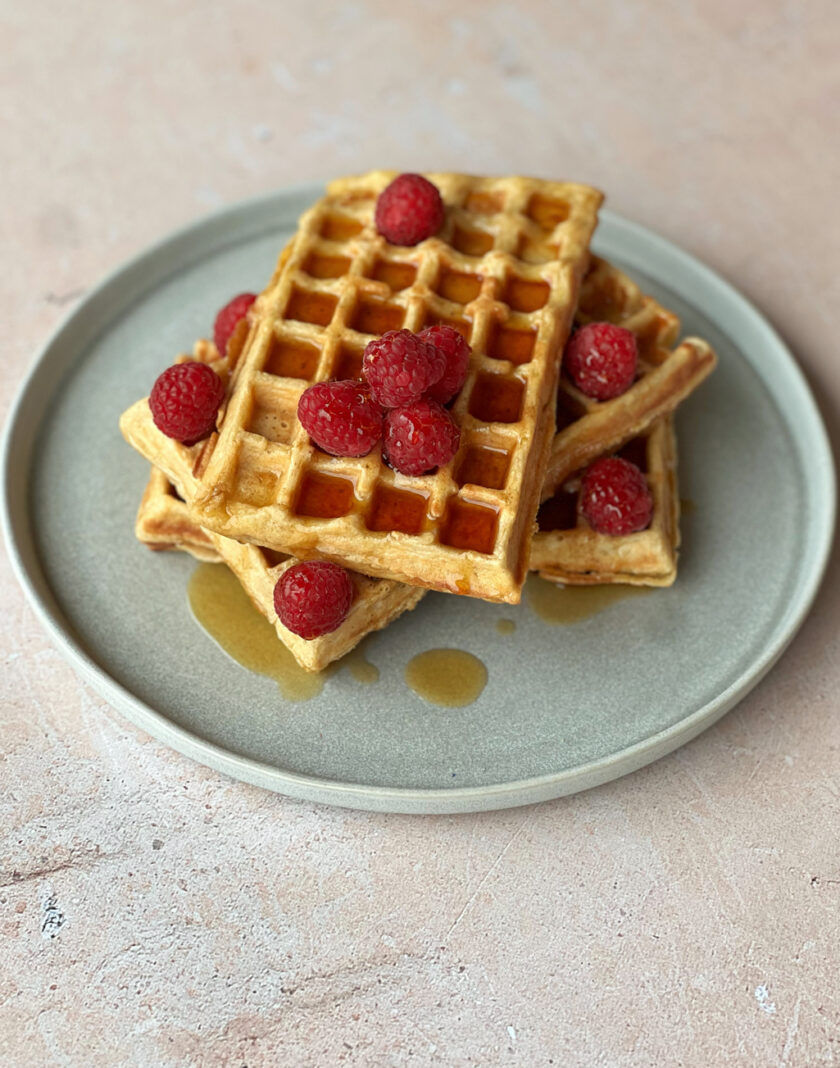 Waffeln ohne raffinierten Zucker auf einem Teller und mit Beeren serviert.