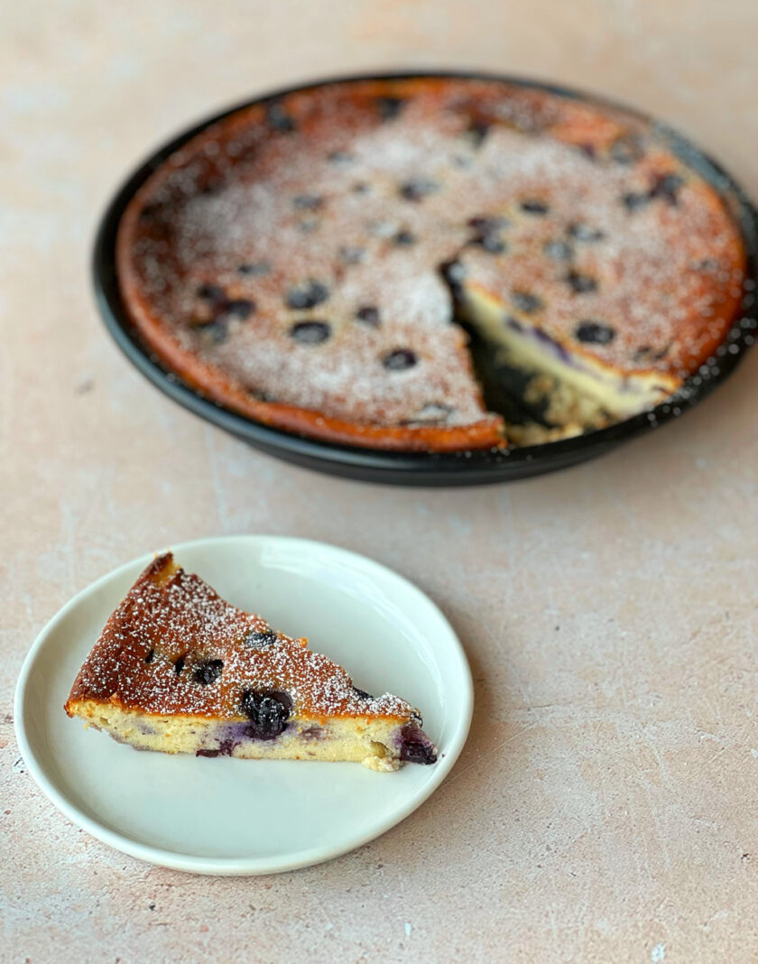 Ricottakuchen mit Heidelbeeren auf einem Teller servieren