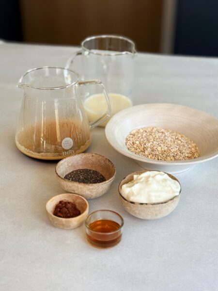 Zutaten: 50 g Haferflocken 2 EL Chiasamen 125 ml Milch 2 Espresso NESCAFÉ 1 TL Ahornsirup 1 TL Kakaopulver + Extra zum Bestäuben 200 g Skyr oder Magerquark
