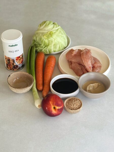300 g Poulet Minifilets 2 EL BBQ Mix @Nahrin_ag 2 EL Sesamöl 300 g Weisskohl 2 Karotten 1 Nekatrine 1 Frühlinszwiebel 2 EL Sojasauce 2 EL Tahina 4 EL Sesamsamen 2-3 EL Wasser