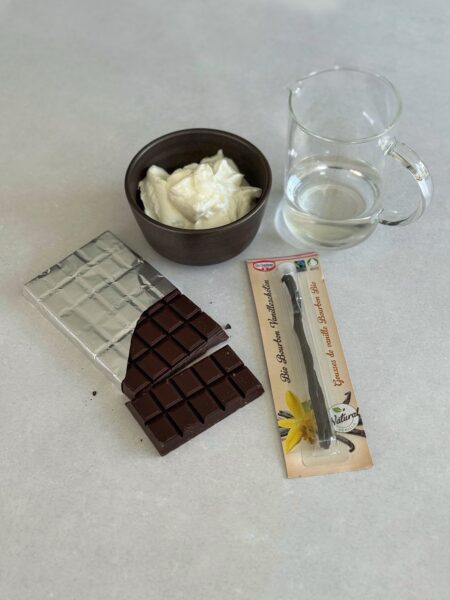 200 g dunkle Schokolade (mind. 70% Kakao) 2 Dr. Oetker Bourbon Vanilleschoten 180 ml Wasser 250 g Magerquark oder Skyr