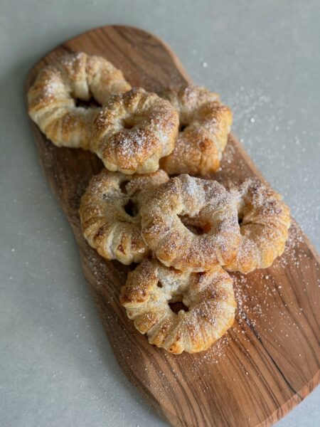 Die Apfel-Blätterteig-Ringe auf das Backblech legen. Wer mag, kann die Ringe auch leicht mit etwas verquirltem Ei bestreichen, um eine goldbraune Farbe zu bekommen. Backen: Die Ringe im auf 200 Grad Ober-/Unterhitze vorgeheizten Ofen ca. 20 Minuten backen, bis der Blätterteig schön aufgegangen und goldbraun ist. Herausnehmen, etwas abkühlen lassen und nach Wunsch mit Puderzucker bestäuben.