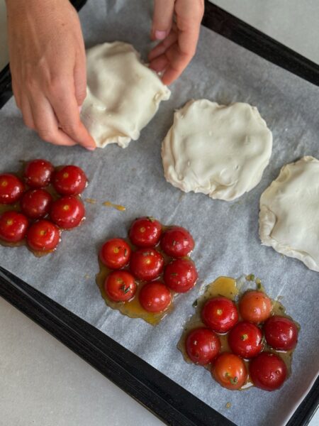 🍅🌿Die Cherry-Tomaten waschen und halbieren. Salbei und Rosmarin fein hacken. 🍅🌿In einer Schüssel die Tomaten mit Olivenöl, gehackten Kräutern, Salz und Pfeffer gut vermengen. 🍅🌿Auf ein mit Backpapier belegtes Blech sechs kleine Kreise aus Honig ziehen. 🍅🌿In die Mitte jedes Honigkreises eine halbierte Tomate mit der Schnittfläche nach unten legen. Anschliessend jeweils sechs Tomatenhälften rundherum platzieren (siehe Bild).