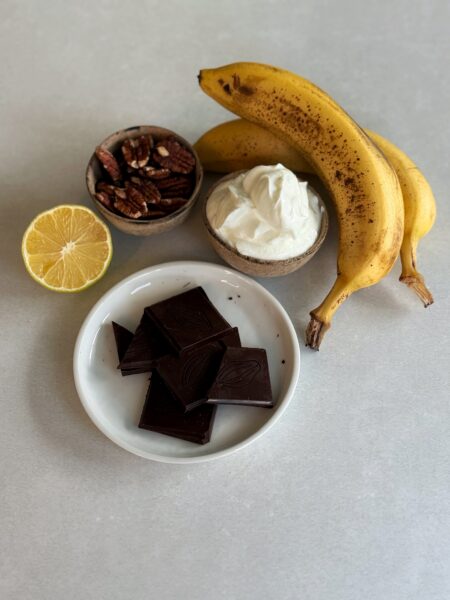Zutaten: 2 Banane (wenn möglich reif) ½ Zitrone 50 g dunkle Schokolade 50 g Pekannüsse 100 g Skyr natur
