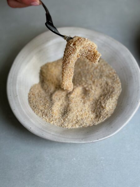 Ei in einer Schüssel mit etwas Salz verrühren, dann die in Mehl gewendeten Pouletstreifen in Ei wenden und von dort dann in Paniermehl wenden.