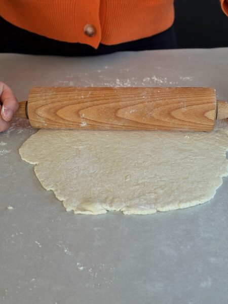 Backofen auf 230 °C Ober-/Unterhitze vorheizen. Ein Pizzastein kann mit aufgeheizt werden, alternativ ein Backblech. Für den Teig Magerquark, Mehl, Backpulver und Salz in einer Schüssel vermengen, zu einem glatten Teig kneten. Den Teig dünn auf Backpapier ausrollen und auf das Backblech oder den Pizzastein legen.