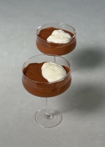 Schokolade schmelzen: Die Schokolade grob hacken und über dem Wasserbad oder vorsichtig in der Mikrowelle schmelzen. Etwas abkühlen lassen, damit sie lauwarm ist. Kakis vorbereiten: Die Kakis schälen, grob zerkleinern und in einem Mixer oder mit einem Pürierstab glatt pürieren. Mischen: Die flüssige Schokolade zum Kaki-Püree geben und gut mixen, bis eine glatte, seidige Creme entsteht. Kühlen: In Gläser oder Schälchen füllen und mindestens 2 Stunden im Kühlschrank fest werden lassen. Mit Kako bestäuben und z.B. mit etwas Rahm oder Joghurt servieren. 